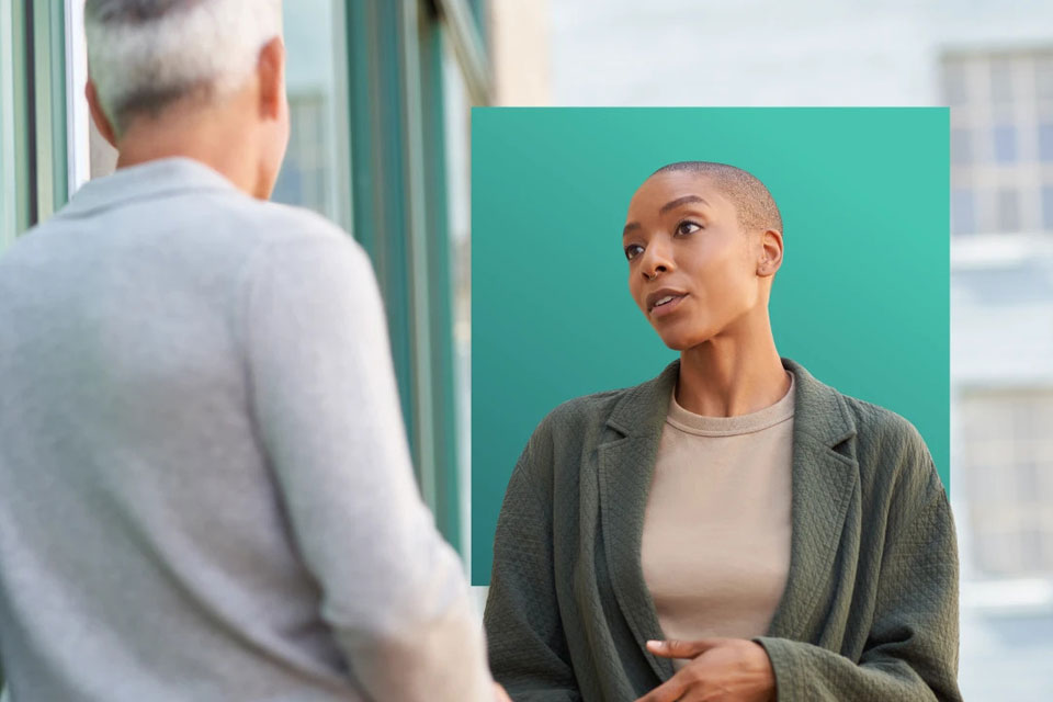 Zwei Personen stehen sich gegenüber und unterhalten sich