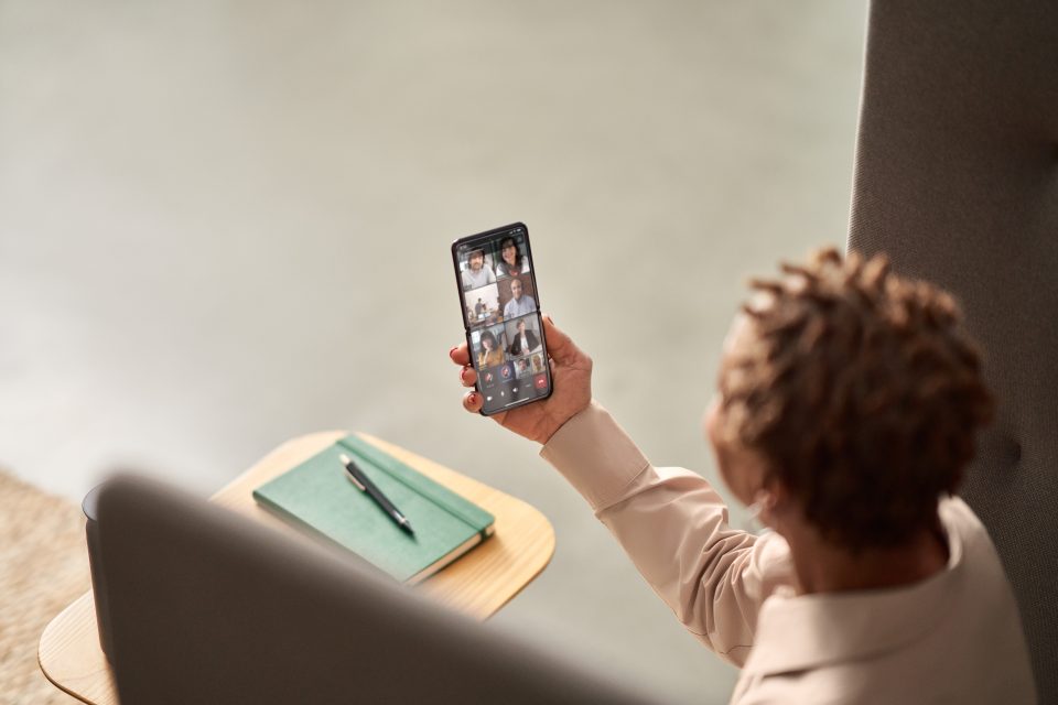 eine person mit smartphone und microsoft teams