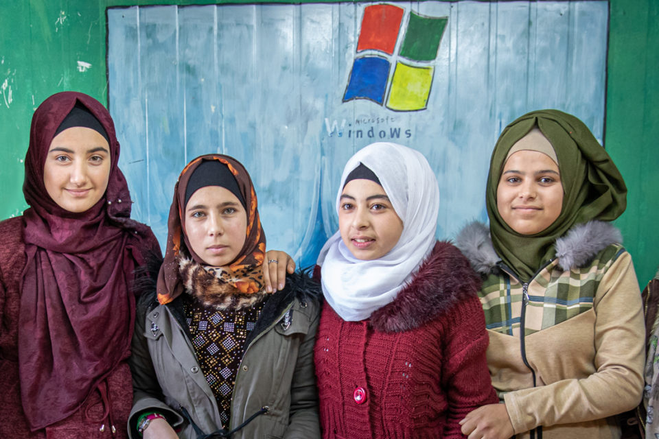 Niñas frente a un logo de Microsoft