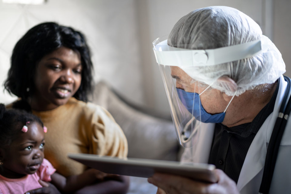 Un doctor y sus pacientes con una tableta