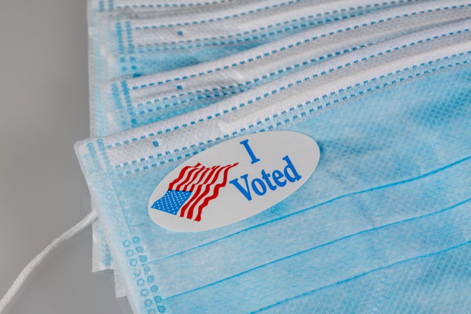 Un adhesivo de I Voted sobre un cubrebocas COVID