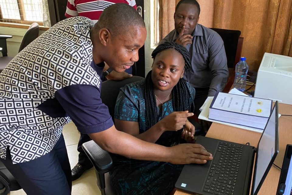 Una mujer y un hombre hablan mientras comparten una laptop