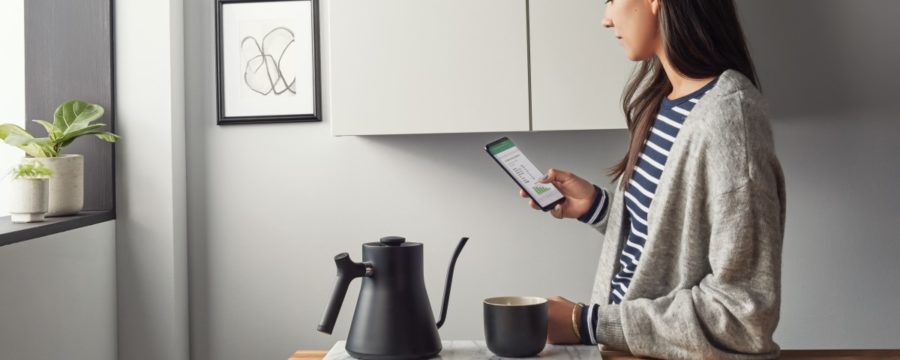 Una mujer trabaja en Excel desde su teléfono Android desde la cocina