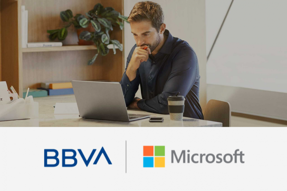 Un hombre en una oficina sentado en un escritorio trabaja en una laptop