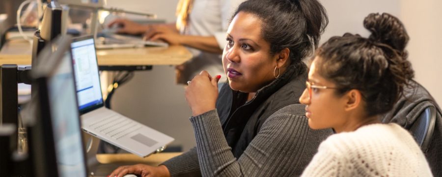 Dos desarrolladoras colaboran en el espacio de su oficina empresarial.