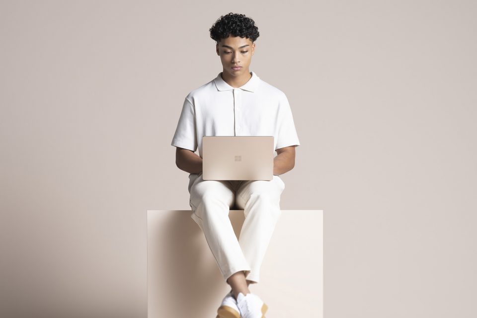 un joven con una Surface Laptop 4
