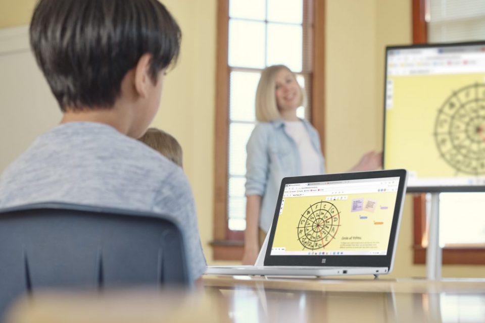 Un niño frente a una laptop en un aula