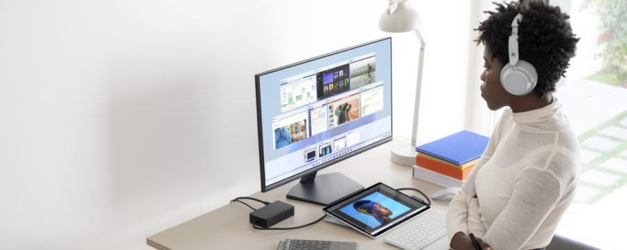 Mujer usa audífonos y trabaja en una laptop