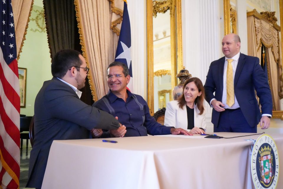 Personas en una mesa se dan la mano