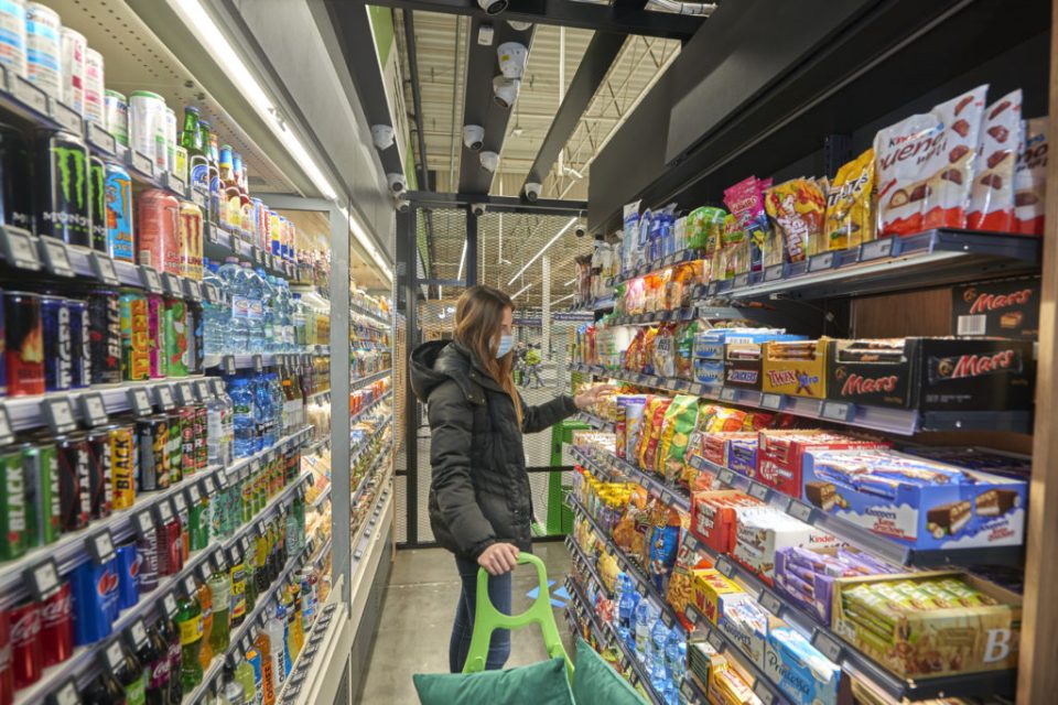 Un comprador examina los alimentos en una tienda Żabka.
