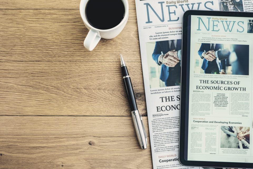 Un periódico y una tableta muestran la misma página de portada