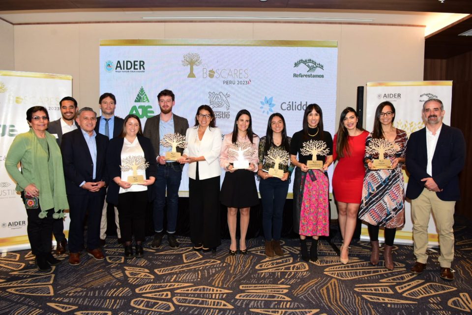 Varias personas en fila sostienen premios
