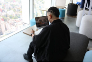 Hombre trabaja con una libreta y una laptop