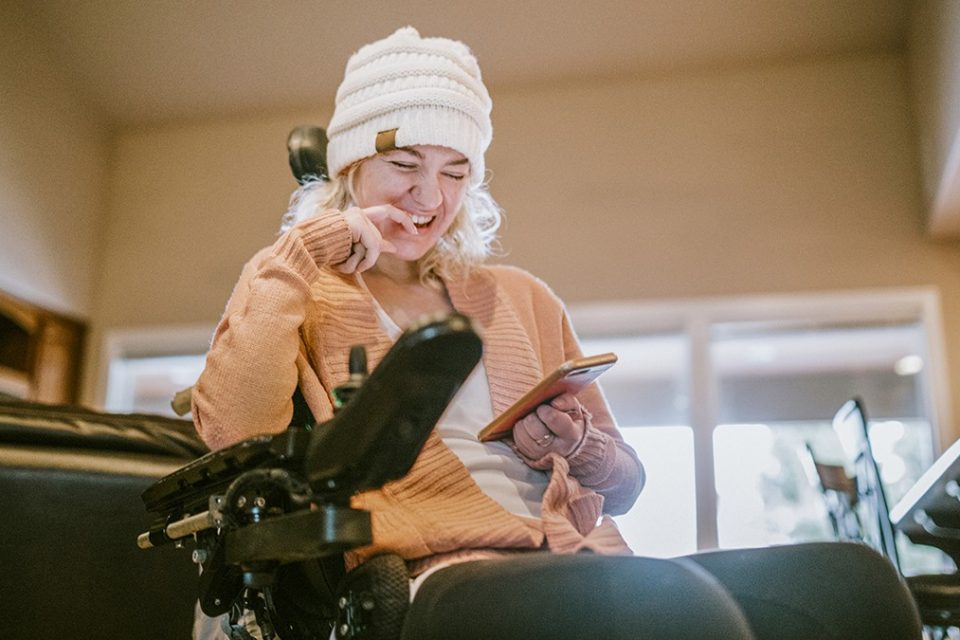 Mujer con discapacidad observa su smartphone