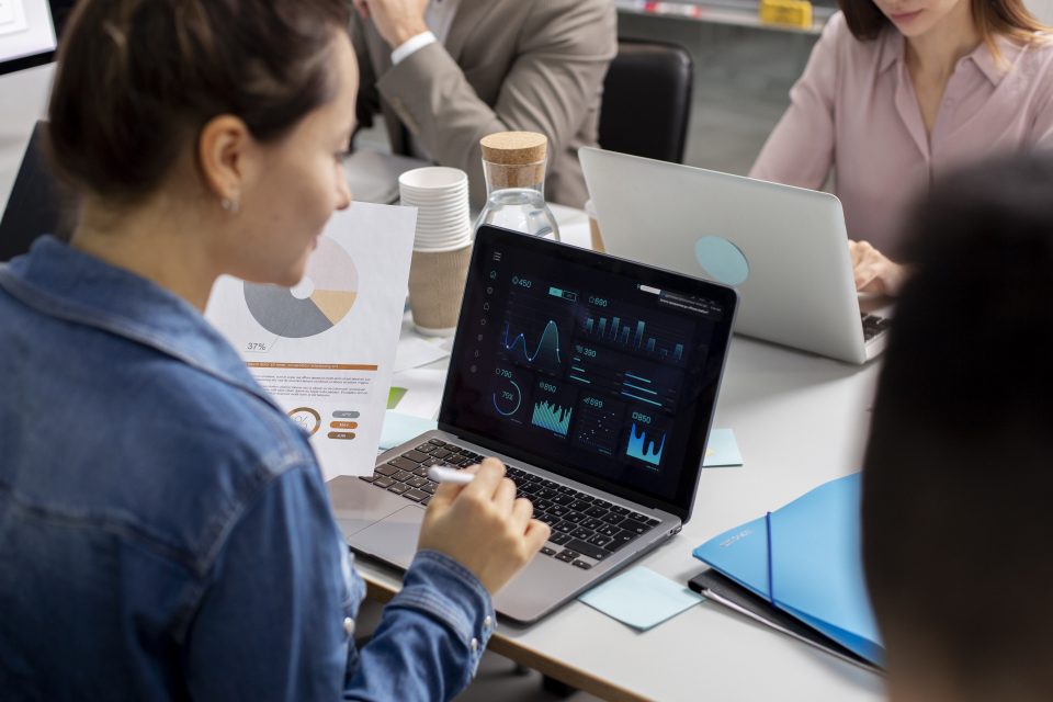Una mujer trabaja en una laptop en una mesa de trabajo