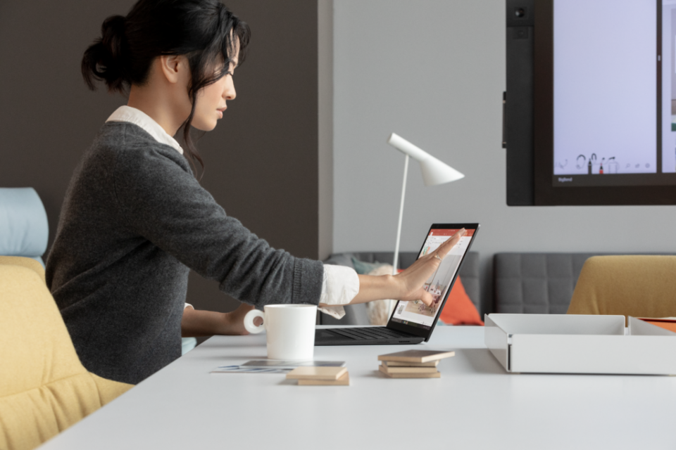 Mujer trabaja con una tableta Microsoft Surface en una sala de juntas
