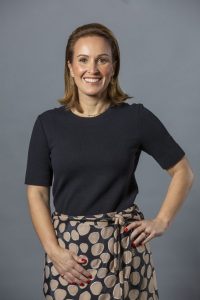 Una mujer con blusa negra y falda en tonos café y negro