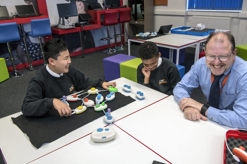 Daniel e Rico conversam com Jonathan Fogg sobre o code Jumper numa sala de aula da New College Worcester.