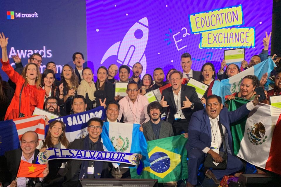 Educadores no palco da E2 comemoram sua participação com bandeiras de seus países.