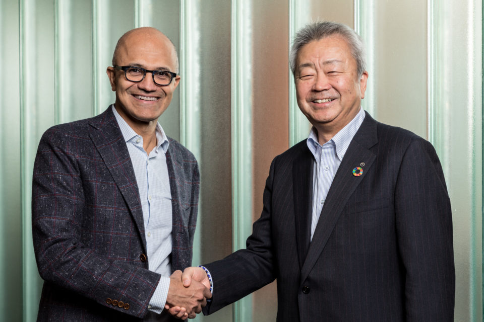 Satya Nadella e Jun Sawada dão as mãos.