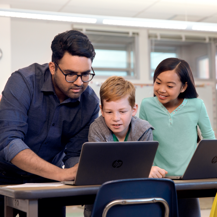 Homem e duas crianças olhando para o computador