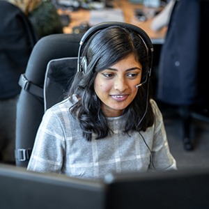 Mulher atrás de um computador com headphone