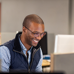 homem sorrindo encarando o note