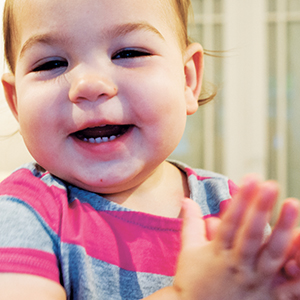 bebê sorrindo e batendo palma