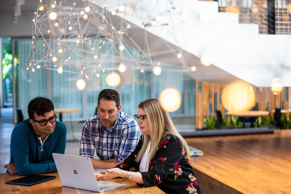 três pessoas trabalhando em mesa