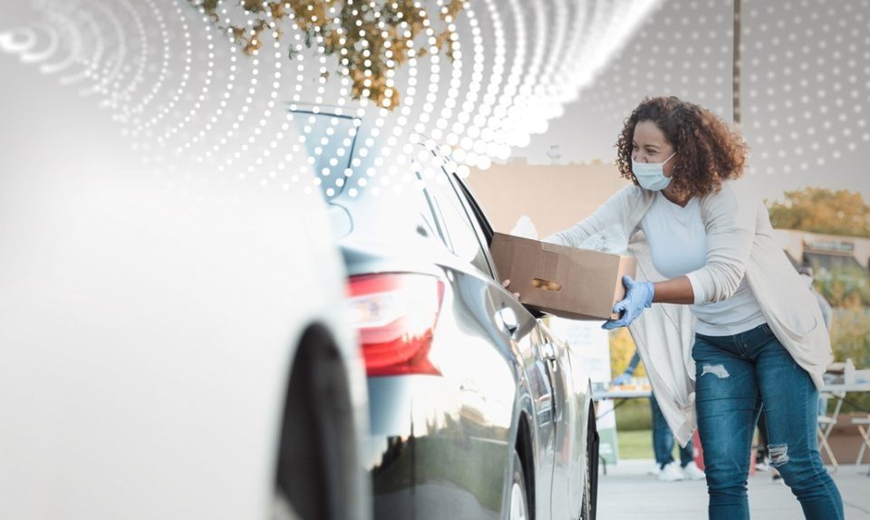 mulher entregando cesta em carro