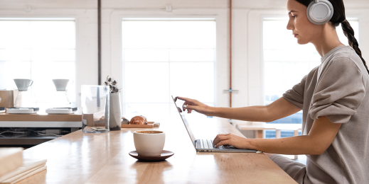 mulher comfone de ouvido trabalhando no computador