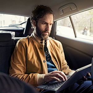 homem no carro mexendo no note