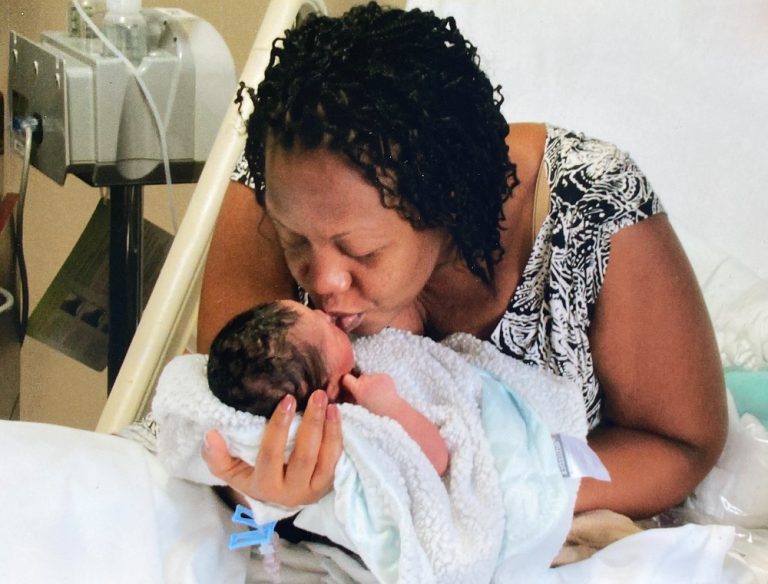 mãe em hospital com filho recém-nascio no colo