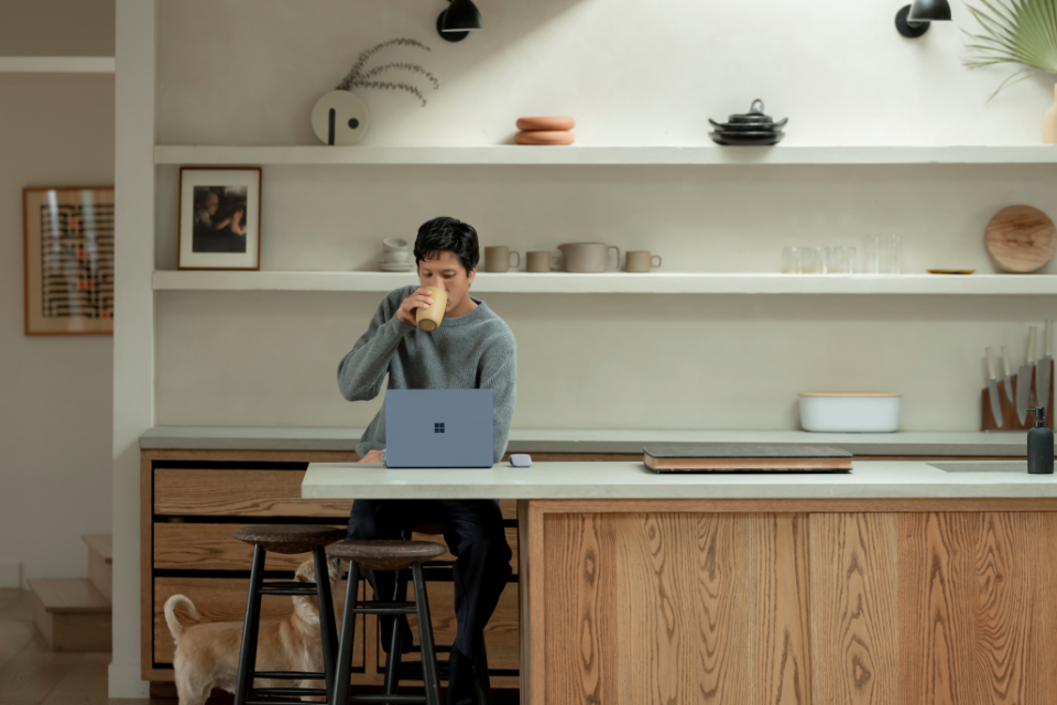 mulher sentada bebendo café a trabalhando no note