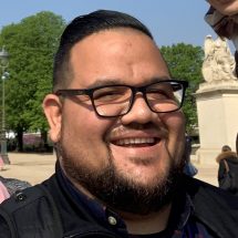 homem de óculos sorrindo