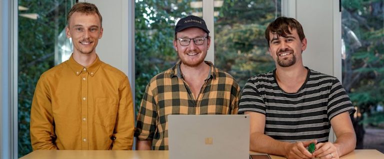 três homens sorrindo com note abert