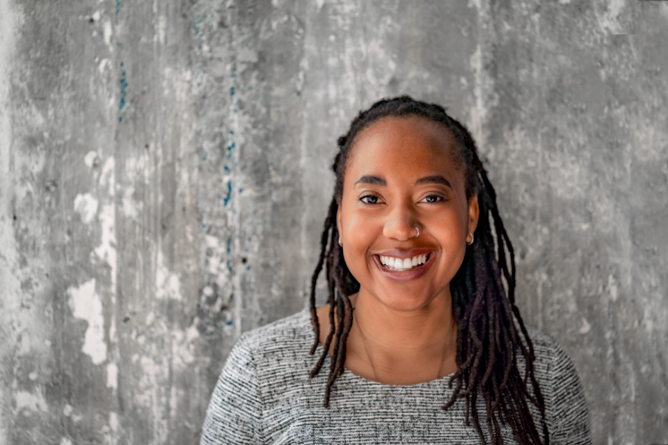 mulher negra de tranças sorrindo