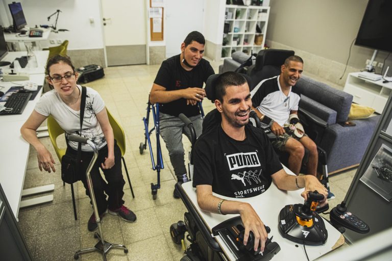 vários jovens em cadeira de roda ao redor um jovem jogando