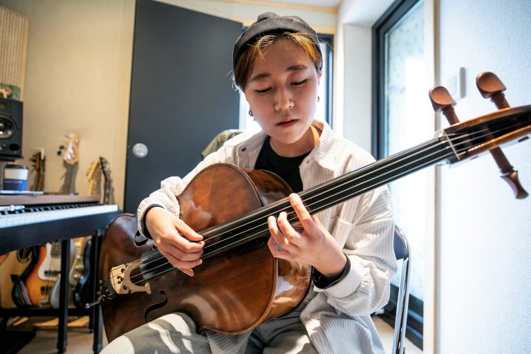 jovem com violão tocando, sentada