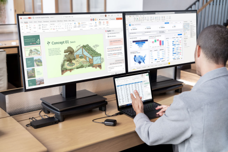 Homem trabalhando em frente a dois computadores