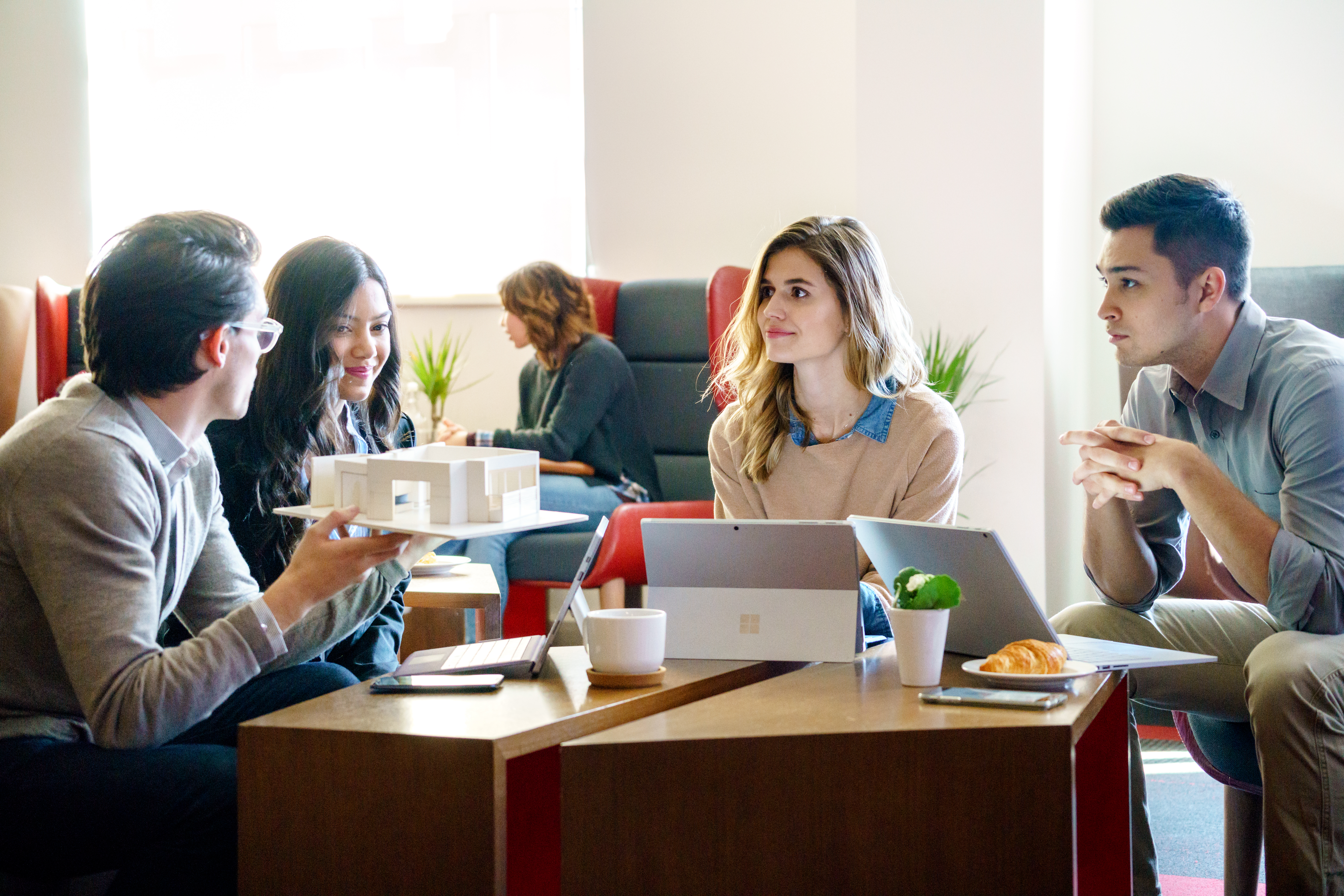 4 people collaborating with laptops