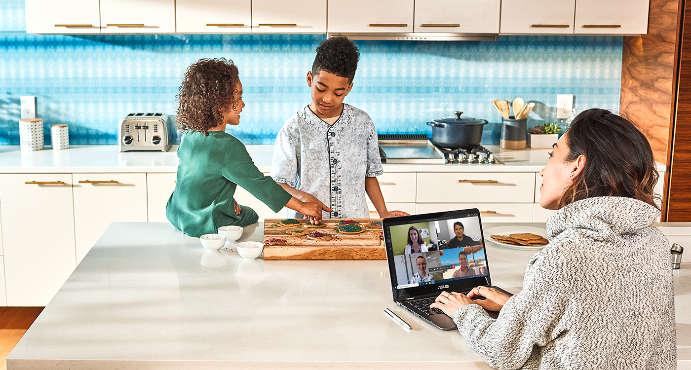 a woman working from home while her kids playing in the kitchen