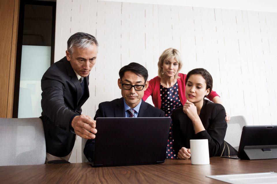 A groupds of business people looking at a laptop