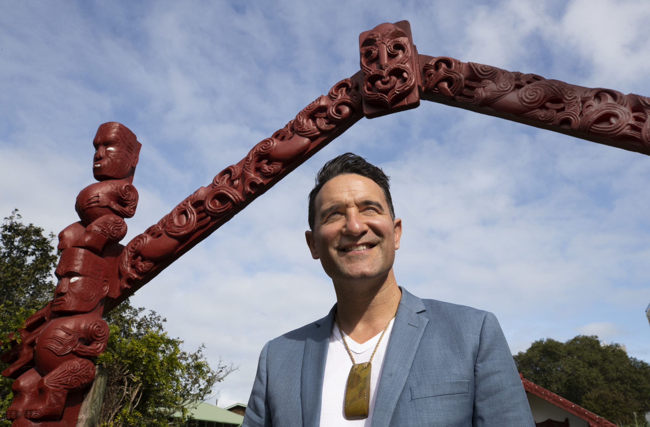 Man stand under Maori carved arch