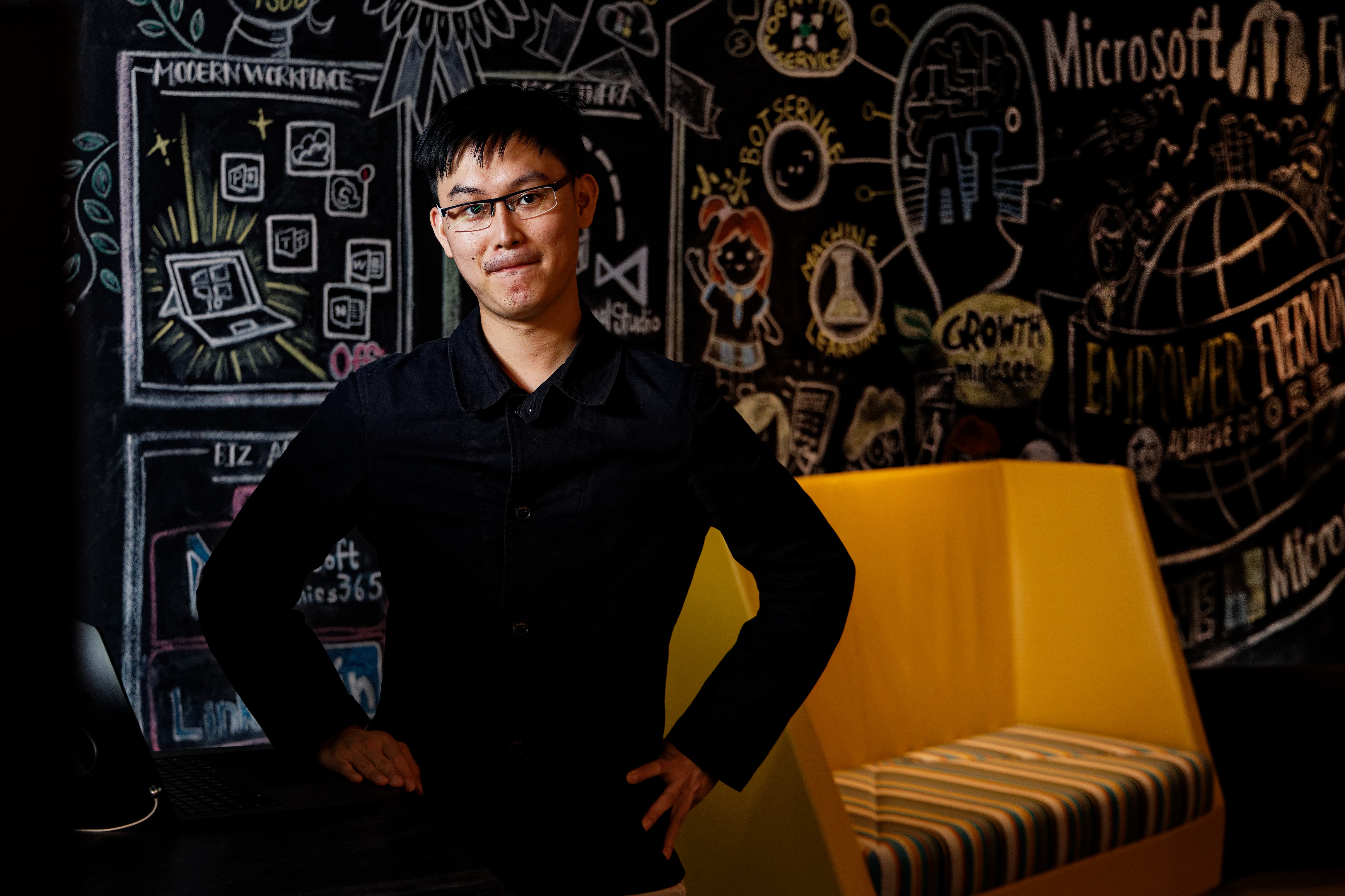 A man stands in front of a chalkboard