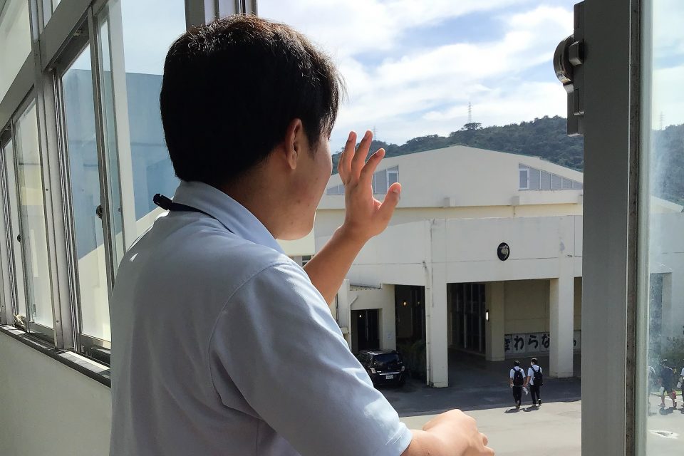 A young man looks out a window