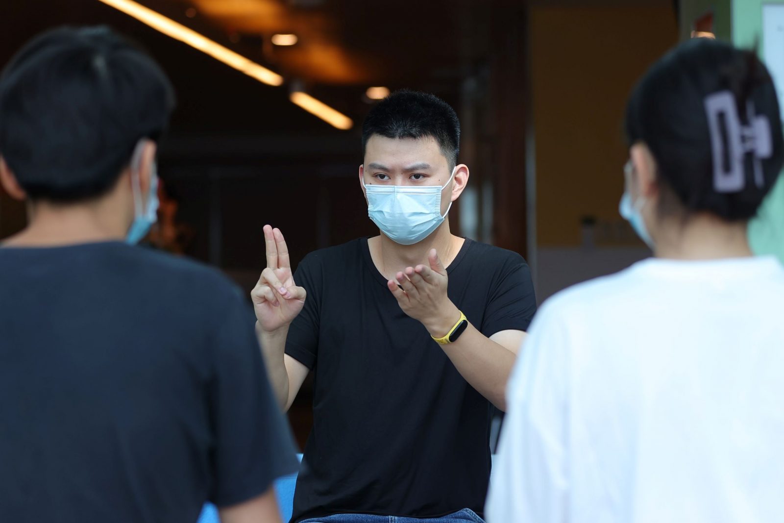 A man in a mask converses in sign language