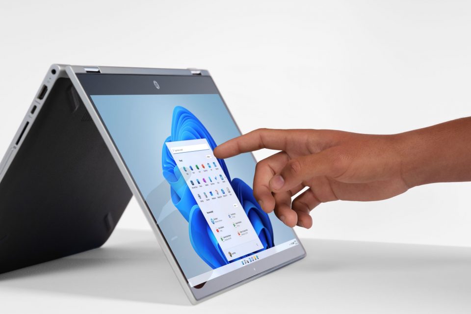 A man's finger touches a laptop screen