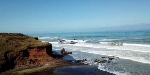 Drone view of rocky beach and ocean.