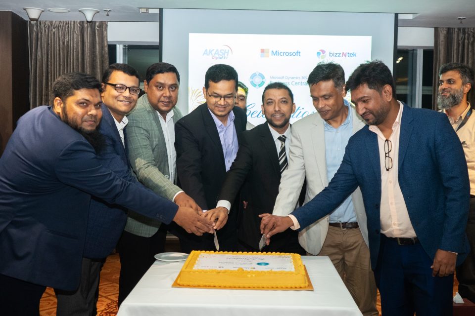 Group of men cutting a cake at a ceremony